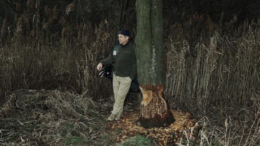 Olivier Widrig leaning against a tree with the Golfyr golf bag on his shoulder