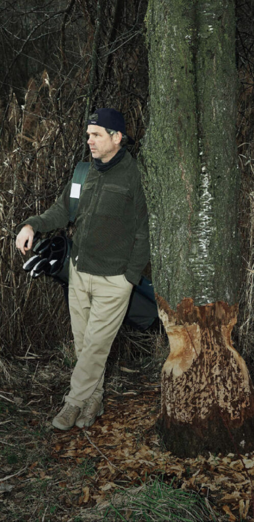 Olivier Widrig leaning against a tree with the Golfyr golf bag on his shoulder