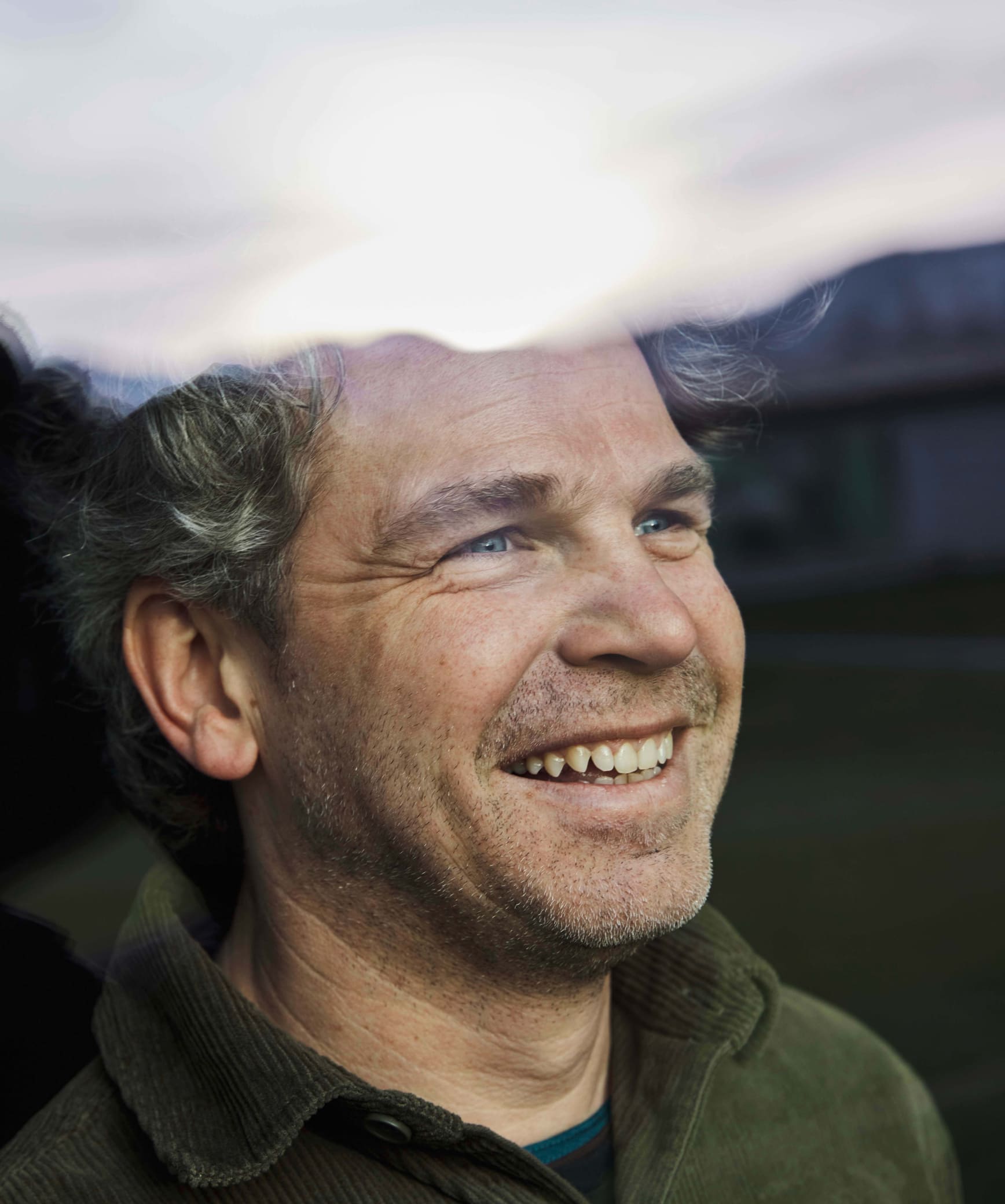 Portrait of Olivier Widrig smiling into the clouds