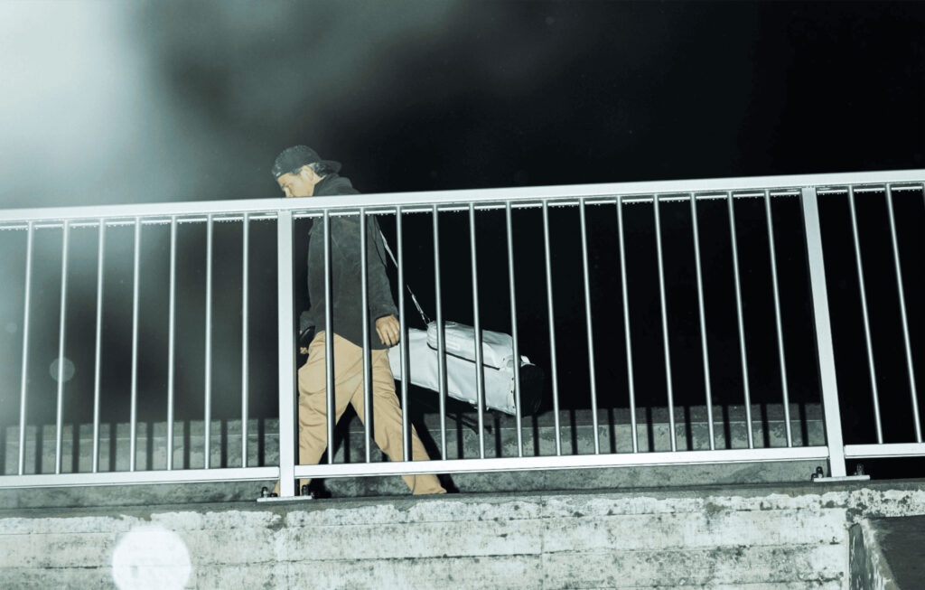Olivier Widrig walks behind a fence with his golf bag around his shoulder