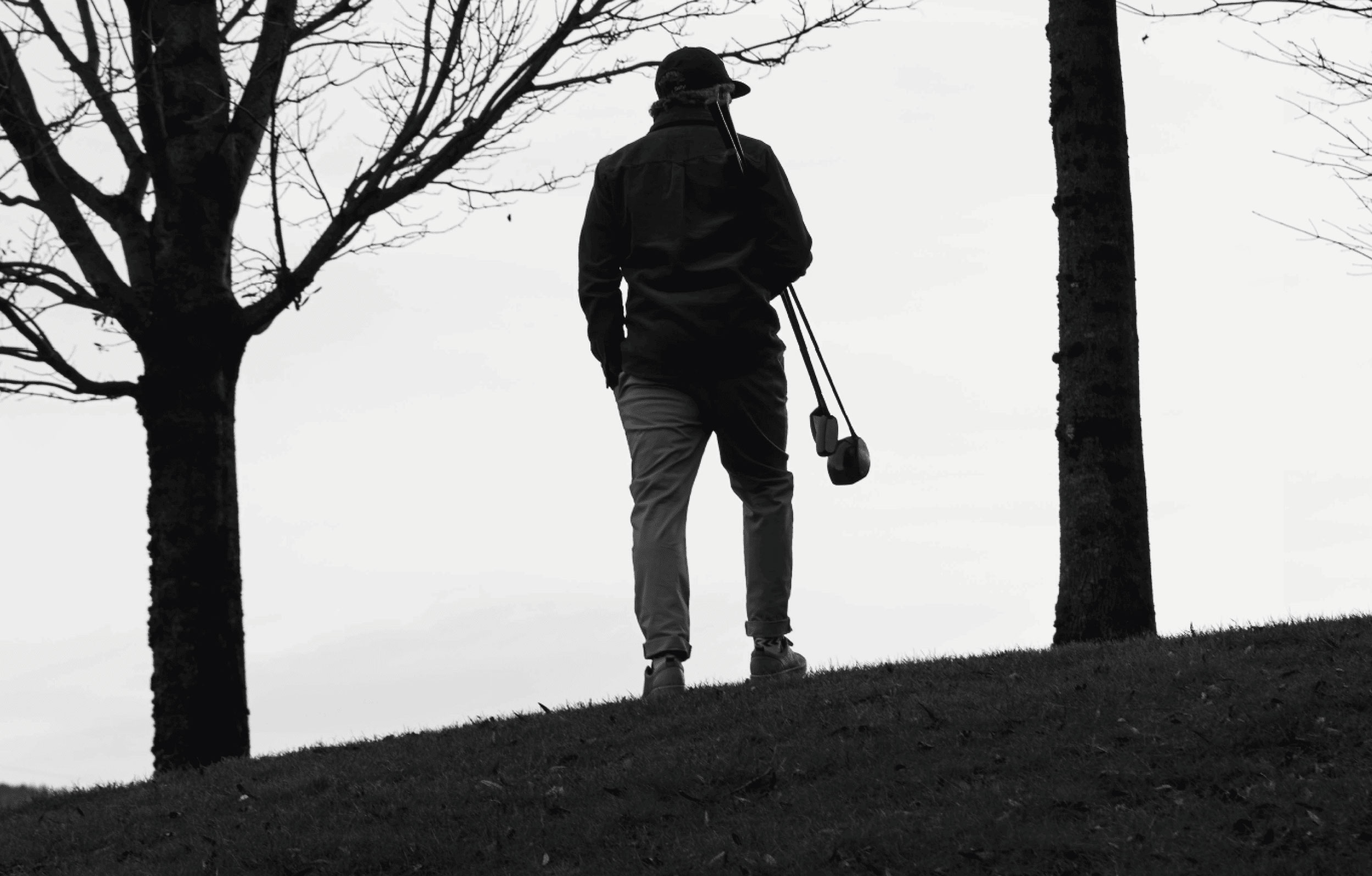Olivier Widrig stands at the top of the hill with two clubs under his arms