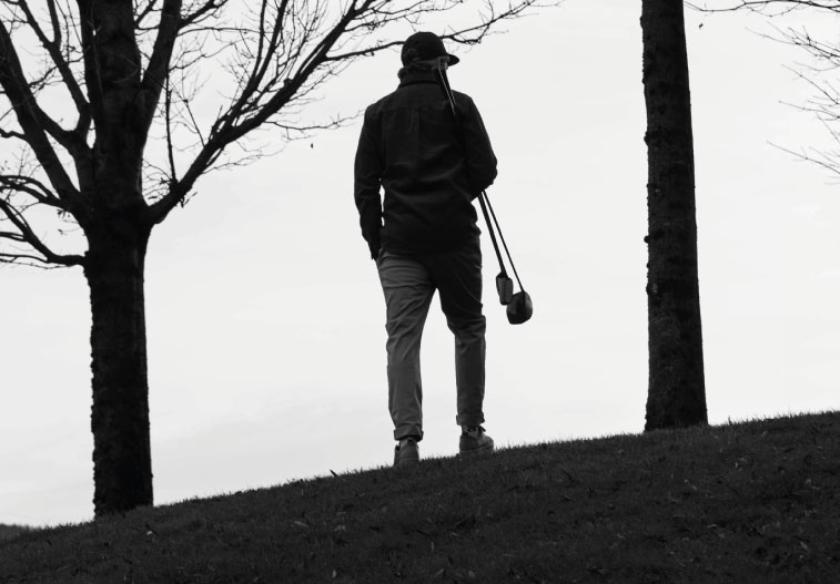 Olivier Widrig stands at the top of the hill with two clubs under his arms