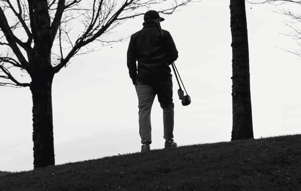 Olivier Widrig stands at the top of the hill with two clubs under his arms