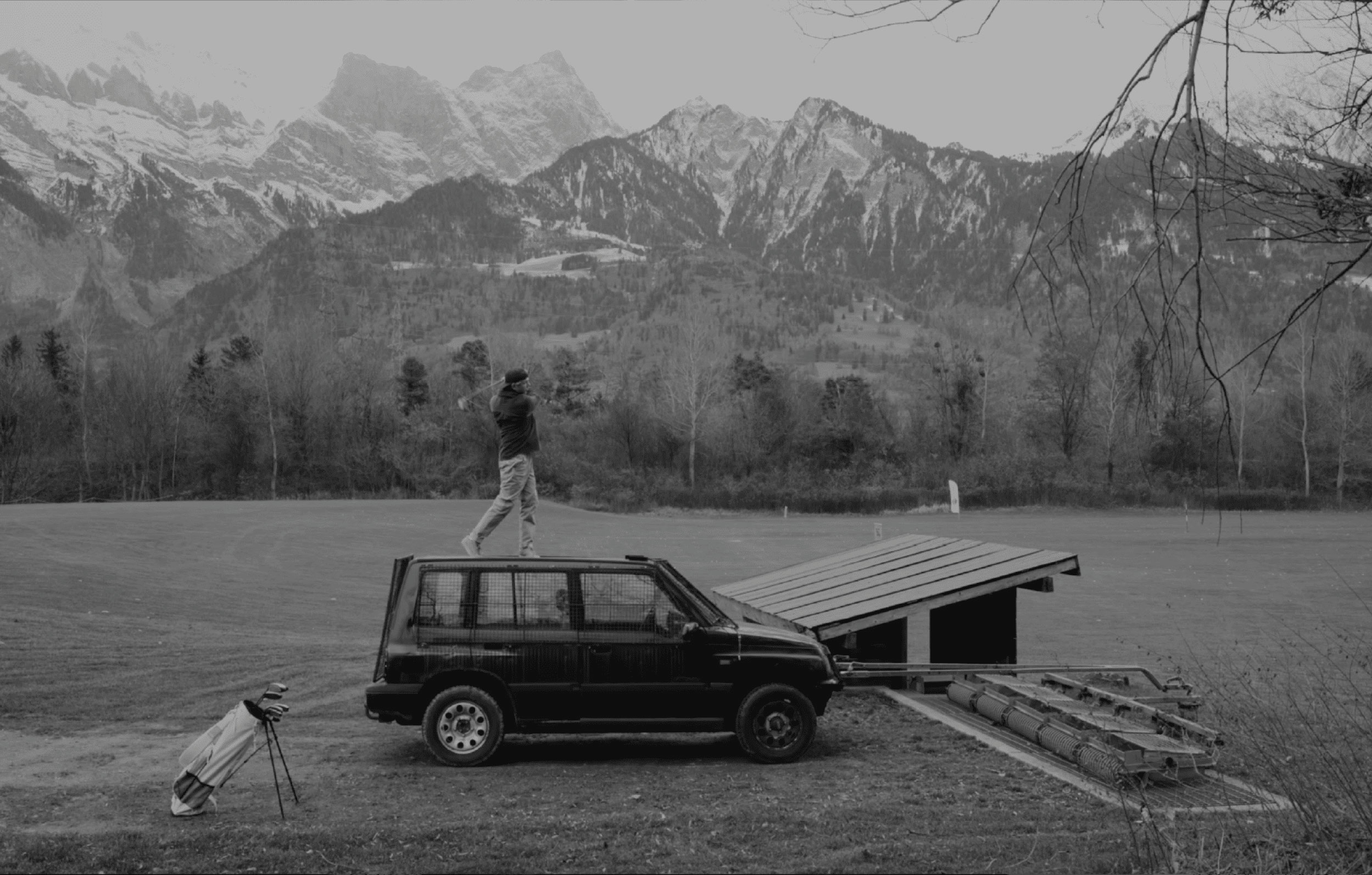 Olivier Widrig stands on a car and hits the tee